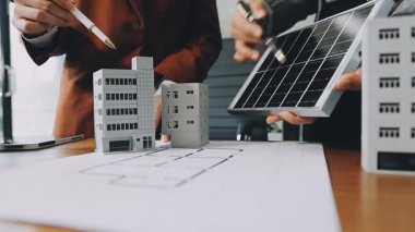 İş adamı ve mimar şehirde, ofiste ev modeliyle çalışıyorlar.