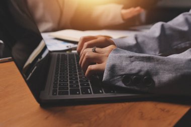 Group of confident business people point to graphs and charts to analyze market data, balance sheet, account, net profit to plan new sales strategies to increase production capacity.