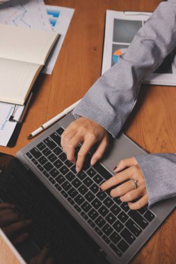 Group of confident business people point to graphs and charts to analyze market data, balance sheet, account, net profit to plan new sales strategies to increase production capacity.