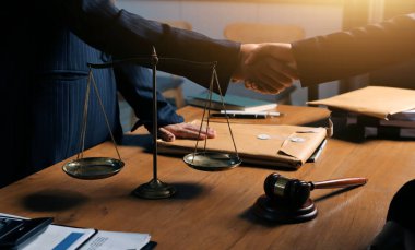 Attractive young lawyer in office Business woman and lawyers discussing contract papers with brass scale on wooden desk in office. Law, legal services, advice, Justice and real estate concept.
