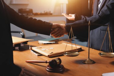 Attractive young lawyer in office Business woman and lawyers discussing contract papers with brass scale on wooden desk in office. Law, legal services, advice, Justice and real estate concept.
