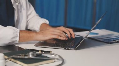 Erkek doktor ofiste tablet kullanıyor.