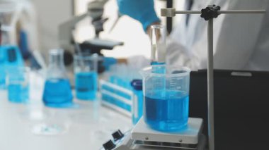 Yakın çekim - bir laboratuvar çalışanı bir sıvı ile test tüpü tutuyor