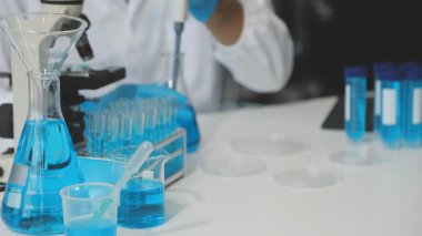 Laboratuvarda deney tüpleri ve sıvı tutan bilim adamlarının ellerini kapatın..