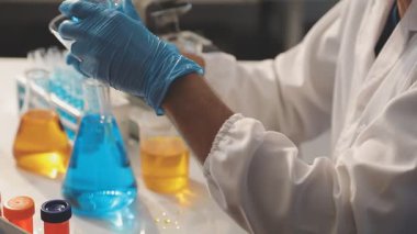 Bilim adamı laboratuvarda sıvı testi yapıyor.