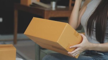 Genç ve güzel bir kadın yeni ofisteki kanepede oturuyor. Online alışveriş kavramı.