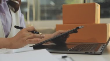 Ofiste dizüstü bilgisayar kullanan genç iş kadını.