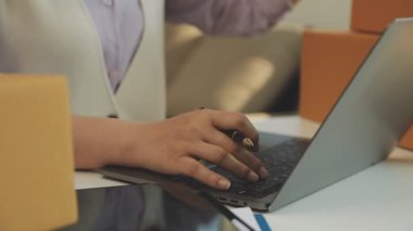 Kapalı - Ofiste alışveriş için bilgisayar kullanan bir kadın müşteri.