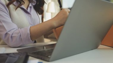 Modern ofiste çalışan bir iş kadını. Genç bir kadın dizüstü bilgisayarda yazıyor..