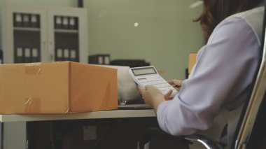 Dizüstü bilgisayarı ve akıllı telefonu olan genç bir kadın..