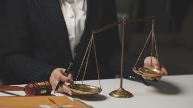 Erkek eli tokmakla teraziyi tutuyor