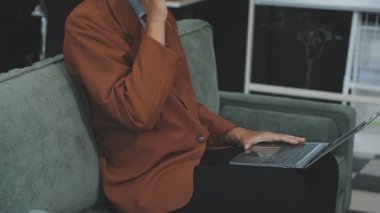 İş kadını koltukta otururken tablet kullanıyor