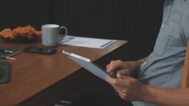 Adam dijital tablet kullanıyor ve ofiste dijital tablet üzerinde çalışıyor..