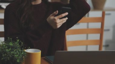 Ofiste dizüstü bilgisayarla çalışan genç bir kadın.