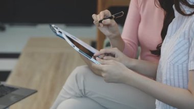 Masanın üzerinde tablet ve tablet kullanan iş kadını.