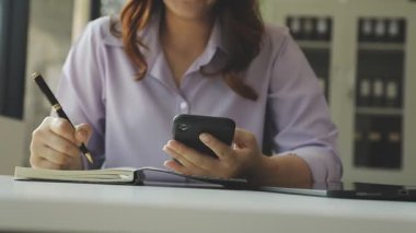 İş yerinde akıllı telefondan yazan kadın.