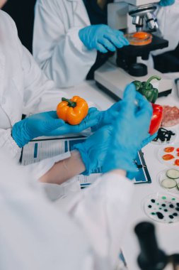 Laboratuvardaki Asyalı bilim adamları mikroskop ve laboratuvar ekipmanları kullanarak gıda araştırmaları yapıyor, gıda bilimi ve biyoteknoloji alanında yenilikler sergiliyorlar.