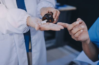 Hemşire yatağında hastalık olan yaşlı bir hastaya yardım ediyor. Tıbbi asistan ve doktor hastane koğuşunda oksijen tüplü ve serum torbalı emekliler için sağlık kontrolü yapıyorlar..