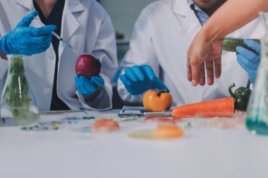 Laboratuvardaki Asyalı bilim adamları mikroskop ve laboratuvar ekipmanları kullanarak gıda araştırmaları yapıyor, gıda bilimi ve biyoteknoloji alanında yenilikler sergiliyorlar.