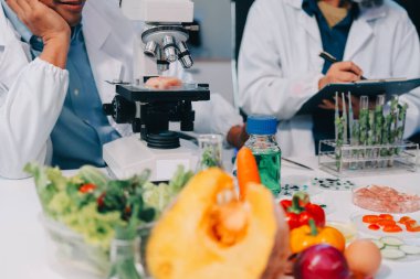 Laboratuvardaki Asyalı bilim adamları mikroskop ve laboratuvar ekipmanları kullanarak gıda araştırmaları yapıyor, gıda bilimi ve biyoteknoloji alanında yenilikler sergiliyorlar.