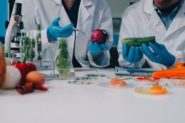 Laboratuvardaki Asyalı bilim adamları mikroskop ve laboratuvar ekipmanları kullanarak gıda araştırmaları yapıyor, gıda bilimi ve biyoteknoloji alanında yenilikler sergiliyorlar.