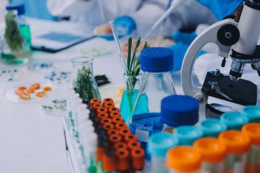 Laboratuvardaki Asyalı bilim adamları mikroskop ve laboratuvar ekipmanları kullanarak gıda araştırmaları yapıyor, gıda bilimi ve biyoteknoloji alanında yenilikler sergiliyorlar.