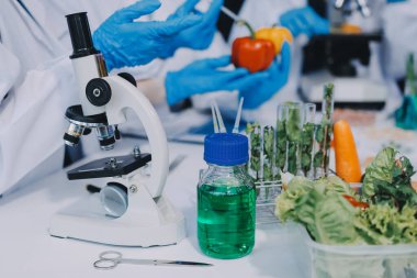 Laboratuvardaki Asyalı bilim adamları mikroskop ve laboratuvar ekipmanları kullanarak gıda araştırmaları yapıyor, gıda bilimi ve biyoteknoloji alanında yenilikler sergiliyorlar.