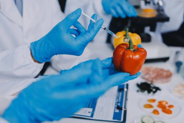 Laboratuvardaki Asyalı bilim adamları mikroskop ve laboratuvar ekipmanları kullanarak gıda araştırmaları yapıyor, gıda bilimi ve biyoteknoloji alanında yenilikler sergiliyorlar.