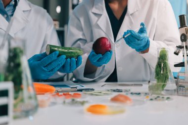 Laboratuvardaki Asyalı bilim adamları mikroskop ve laboratuvar ekipmanları kullanarak gıda araştırmaları yapıyor, gıda bilimi ve biyoteknoloji alanında yenilikler sergiliyorlar.