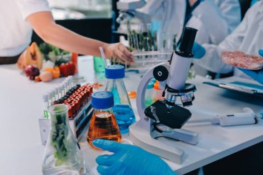 Laboratuvardaki Asyalı bilim adamları mikroskop ve laboratuvar ekipmanları kullanarak gıda araştırmaları yapıyor, gıda bilimi ve biyoteknoloji alanında yenilikler sergiliyorlar.