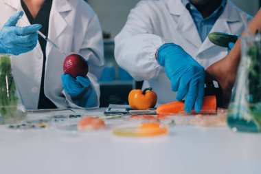 Laboratuvardaki Asyalı bilim adamları mikroskop ve laboratuvar ekipmanları kullanarak gıda araştırmaları yapıyor, gıda bilimi ve biyoteknoloji alanında yenilikler sergiliyorlar.