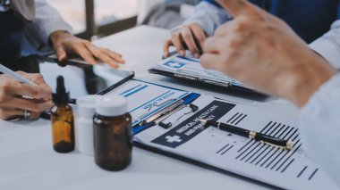 Erkek ve kadın doktorlar bir hastane odasında toplantı yapıyorlar..