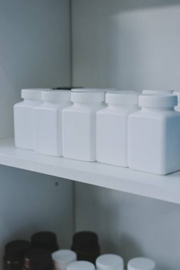 Eczane rafları, ilaç şişeleri, güneş ışığı, sağlık hizmetleri.