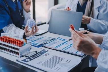 Erkek ve kadın doktorlar bir hastane odasında toplantı yapıyorlar..