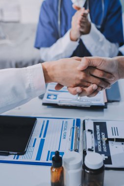 Erkek ve kadın doktorlar bir hastane odasında toplantı yapıyorlar..