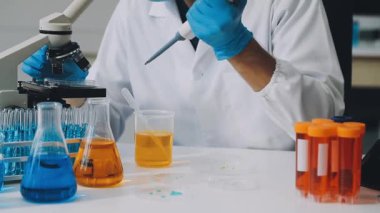 Bilim adamı laboratuarda sıvı ile test tüpü yapıyor.