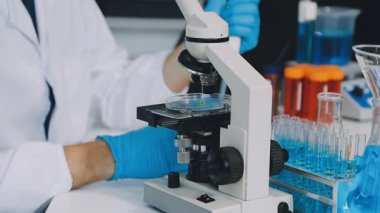 Laboratuarda mikroskop tutan bir bilim adamı..