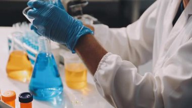 Laboratuvar araştırması, koruyucu gözlüklü bilim adamı laboratuarda test tüpleriyle çalışıyor. Laboratuvardaki kadın bilim adamına yakın çekim. bilimsel deney ve biyoloji