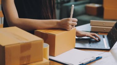 İş kadını ev ofisinde dizüstü bilgisayar ve paket kutuları ile çalışıyor, online alışveriş konsepti, teslimat hizmeti