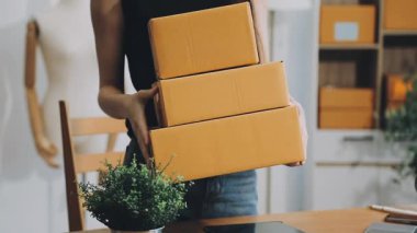 Kadın evden online alışveriş için kutu paketlemeye hazırlanıyor.