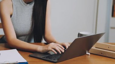 Dizüstü bilgisayarı ve akıllı telefonu olan genç bir kadın.