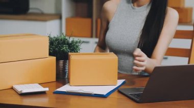 Genç bayan bir teslimat ofisinde paket paketliyor. Ofiste çalışan kadın..