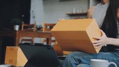 Ev teslimat servisindeki kadın. Kadın kutuları paketliyor ve online iş için hazırlanıyor..