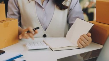 Ofiste çalışan bilgisayar ve kutuyla çalışan kadın..