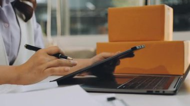 Kadın eli çevrimiçi alışveriş için tablet ve laptop kullanıyor.