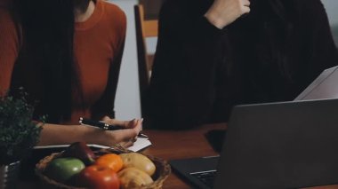 Dizüstü bilgisayarı ve akıllı telefonu olan genç bir iş kadını.