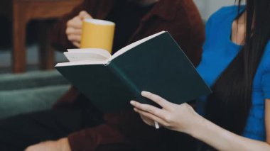 Kız kütüphanede kitap okuyor.