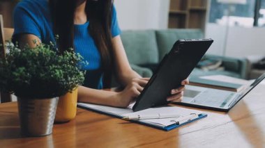 Kadın tablet kullanıyor ve ofiste tablet bilgisayarla çalışıyor..