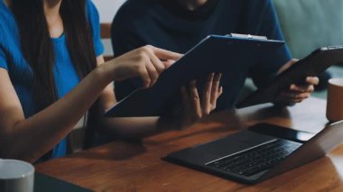 İki genç Asyalı iş kadını ofiste birlikte çalışıyor..