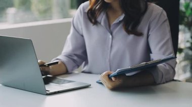 Dizüstü bilgisayarla çalışan genç bir kadın.